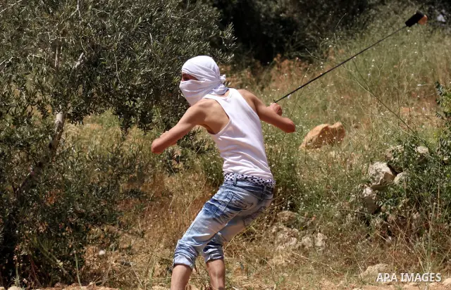A Palestinian youth uses a sling to hurl stones at Israeli soldiers during clashes in the West Bank village of Nabi Saleh, on 28 May 2010. Palestinians protest weekly against the neighbouring Jewish settlement of Halamis...