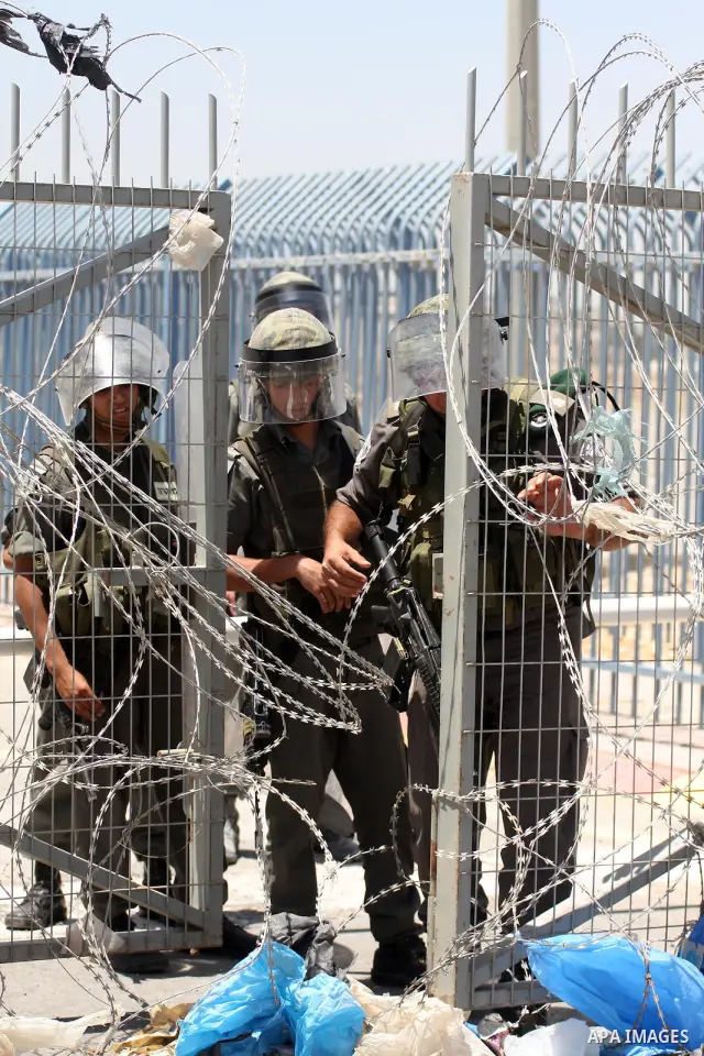 Israeli soldiers take position as Palestinians demonstrate at the Qalandia checkpoint near the West Bank city of Ramallah on May 31, 2010. Israeli commandos stormed a convoy of Gaza-bound aid ships on Monday and more tha...