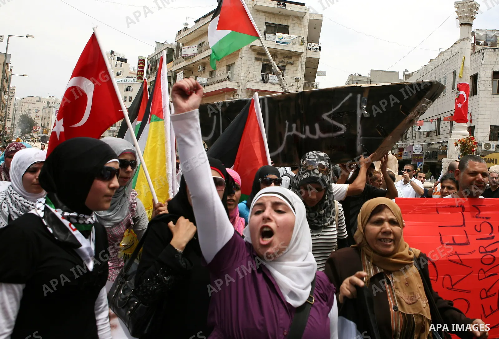 Palestinian and foreign activists take part in a protest in the West Bank city of Ramallah against the storming of Gaza-bound ships, June 1, 2010. Israeli police jailed or deported on Tuesday hundreds of international ac...