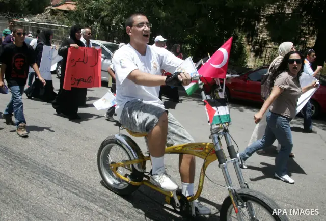 Palestinians wave Turkish flags in front of the Turkish consulate in east Jerusalem during a protest against the Israeli naval commando raid on a flotilla attempting to break the blockade on Gaza on June 1, 2010. Photo b...