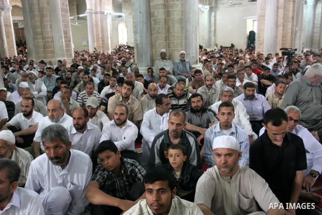 Palestinians attend Friday prayers at al-Omari mosque in Gaza City while Palestinian Prime Minister in Gaza Strip, Ismail Haniyeh speaks about Israel's seizure of a Gaza-bound aid ship on June 4, 2010. Israeli marines st...