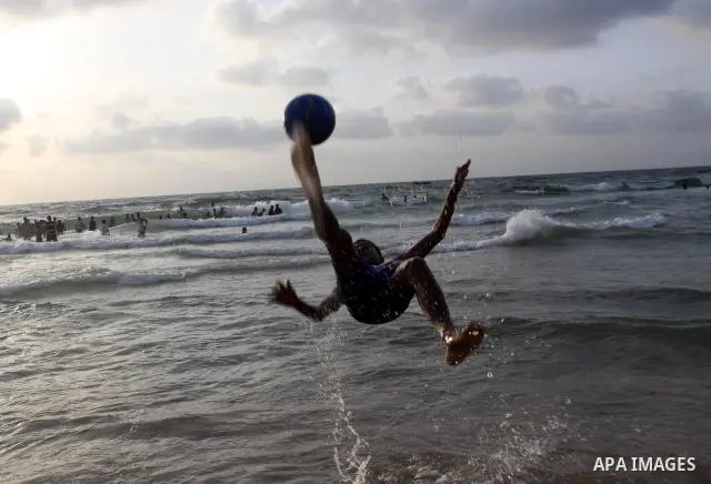 A Palestinian youth plays with a ball during the sunset in Gaza city beach on June 4,2010. Photo by Mohammed Asad