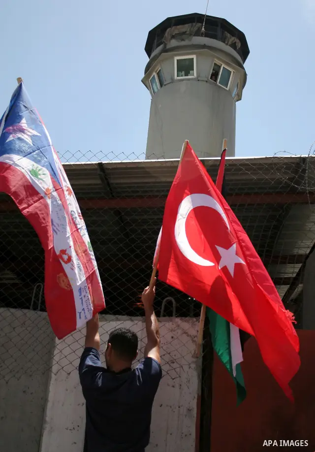 A Palestinian protestor holds up his national flag and the Turkish flag during a demonstration in the West Bank village of Beit Omar, near Hebron, on 05 June 2010. Israeli forces seized Saturday the Gaza-bound 1,200-ton...