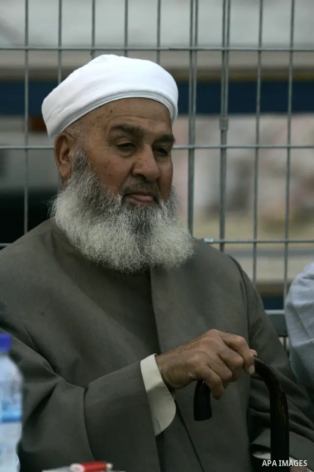 A Palestinian Legislative Council member, Hamed Al-Betawi look at Palestinian politicians, business men and others from different religious communities as they take part in a soccer match in the northern West Bank town o...