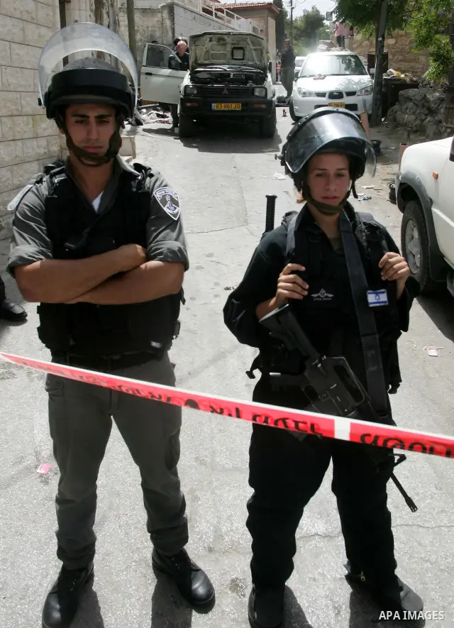 Israeli anti-riot policemen stand next to the bullet-pierced vehicle of a Palestinian man shot dead after he struck two of security officers with his car in mostly Arab east Jerusalem on June 11, 2010. Photo by Mahfouz A...