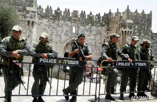 Israeli border policemen stand guard next to Palestinian Muslim worshippers as they perform Friday noon prayer outside Jerusalem's Old City Damascus Gate on June 11, 2010. A Palestinian man shot dead after he struck two...