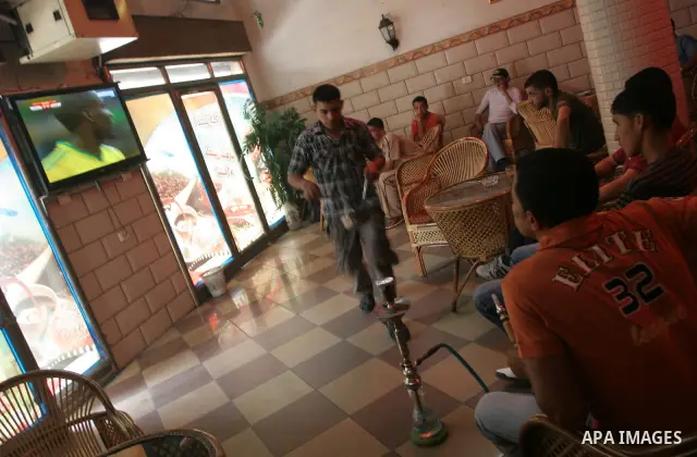 Palestinian youths watch the football opening match of the World Cup 2010 at a coffee shop in the central Gaza Strip town of Deir Al-Balah on June 11,2010. the opening match gathered South Africa team and Mexico team. Ph...