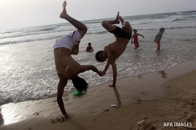 Palestinians enjoy the beach in Gaza City, Friday, June 11, 2010. Gaza has been mired in poverty for decades, but the embargo by Israel deepened the misery, erasing tens of thousands of jobs and preventing repair of dama...