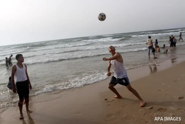 Palestinians enjoy the beach in Gaza City, Friday, June 11, 2010. Gaza has been mired in poverty for decades, but the embargo by Israel deepened the misery, erasing tens of thousands of jobs and preventing repair of dama...