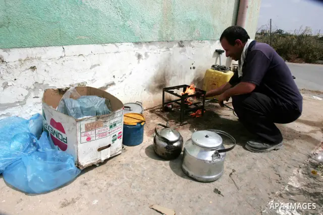 A Palestinian man makes tea for Palestinians as they wait to cross to Egypt, at Rafah border crossing, southern Gaza Strip on June 12, 2010. The opening of Gaza's gateway to the world has turned into a scene of extreme a...