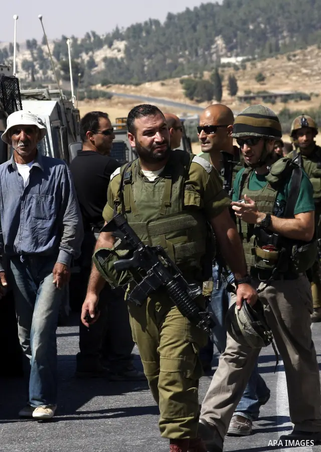 Israeli soldiers stand at the scene of an attack near the West Bank Jewish settlement of Beit Hagai, south of Hebron June 14, 2010. Suspected Palestinian gunmen shot dead an Israeli policeman and wounded two others in an...