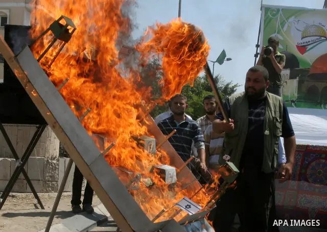 Palestinian Hamas supporters burn a model of an Israeli jail during a rally called by the Islamist movement next to the Red Cross offices in Gaza City on June 14, 2010. Photo by Mohammed Asad