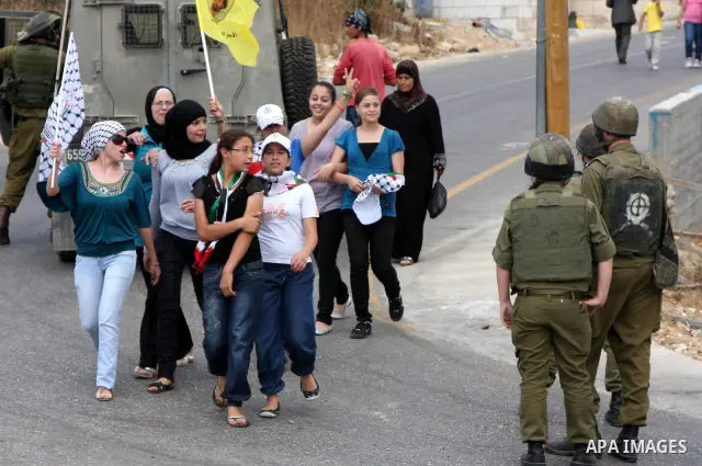 Israeli soldiers take position as Palestinian demonstrators protest against the expansion of the nearby Jewish settlement of Halamish in the West Bank village of Nabi Saleh, Friday june ,25 2010. Photo by Wagdi Eshtayah