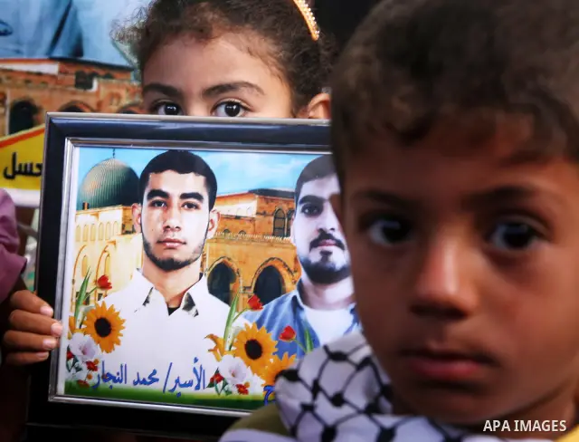Palestinian women and children hold pictures of jailed relatives during a protest calling for the release of Palestinian prisoners from Israeli jails at the Red Cross office in Gaza City on June 28,2010. Photo by Ali Jad...