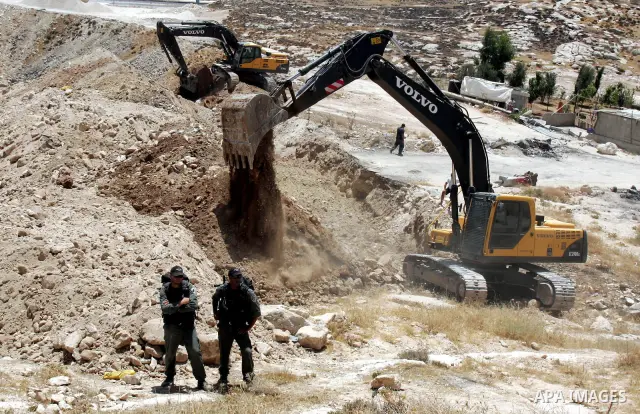Israeli soldiers stand guards as a bulldozer destroys Palestinian farm in the Jerusalem Arab neighborhood of Isawiyya on June 29,2010. Photo by Mahfouz Abu Turk
