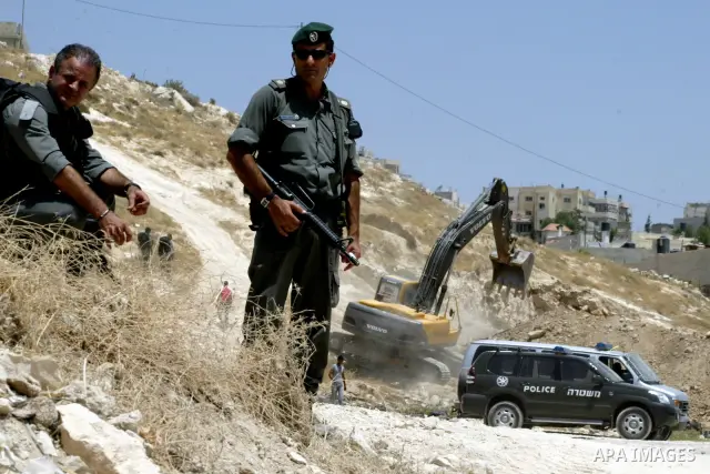 Israeli soldiers stand guards as a bulldozer destroys Palestinian farm in the Jerusalem Arab neighborhood of Isawiyya on June 29,2010. Photo by Mahfouz Abu Turk