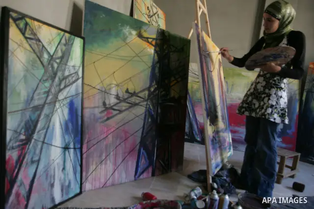 A Palestinian artist, Rofedah Sehwail performs the suffering of Gaza Strip from the power outages in her drawings in the southern Gaza Strip town of Rafah on July 2,2010.Photo by Hatem Omar