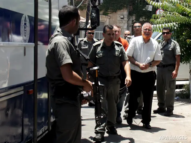Palestinian lawmaker Mohammed Abu Teir is escorted into in front of red cross headquarters in Jerusalem, Sunday on July 4, 2010. Israel has stripped Abu Teir of his Jerusalem residency because he belongs to the Islamic m...