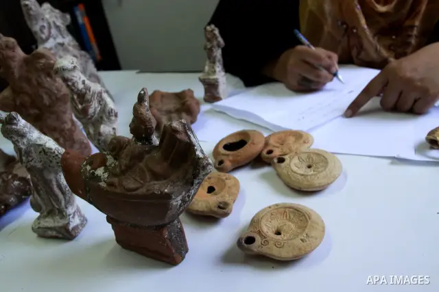 A Palestinian archaeologist displays some of the Canaanite remains that was recently discovered in the Gaza Strip, at the headquarters of the Ministry of Tourism in Gaza City on July 5,2010. Some of these remains return...