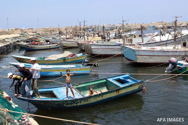 Palestinian boys enjoy swimming at the port of Gaza city on July 5,2010. A Palestinian fisherman was wounded by a shell fired by Israel's navy, Palestinian medics said. Photo by Mohammed Asad