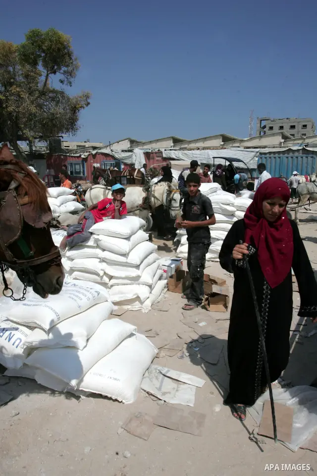 Palestinians receive their human aids from the United Nations Relief and Works Agency (UNRWA) warehouse in the southern Gaza Strip town of Rafah on July 7, 2010. US President Barack Obama and Israeli Prime Minister Benja...
