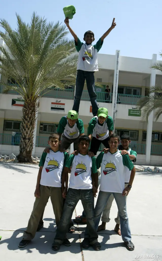 Palestinian boys perform exercises during a summer camp run by Hamas in Gaza City on July 8,2010. In Gaza, summer camps aren't just about swimming, crafts and volleyball. They're about capturing the hearts of children. I...