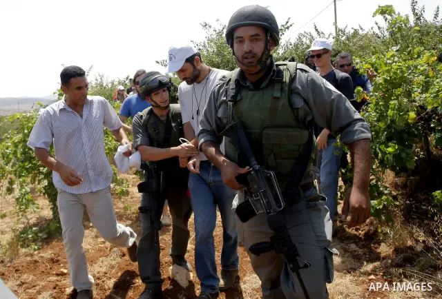 Israeli troops arrest a protester during a demonstration in Beit Omar village, north of Hebron, on July 10, 2010 against Israel's controversial separation barrier and the expansion of nearby Jewish settlements in the occ...