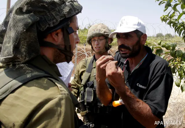 A Palestinian man argues with an Israeli soldier during a demonstration in Beit Omar village, north of Hebron, on July 10, 2010 against Israel's controversial separation barrier and the expansion of nearby Jewish settlem...