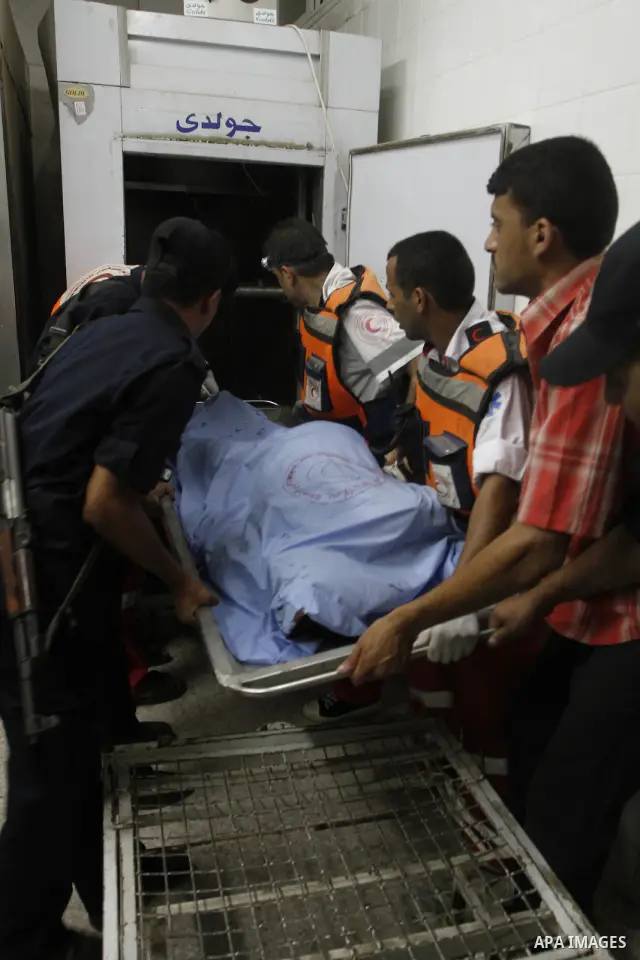 Palestinian medical workers carry the body of Nema Abu Said, 46 to the morgue of al-Aqsa hospital after Israeli shelling in the central Gaza Strip July 13, 2010. Israeli army shelling killed a Palestinian woman and wound...