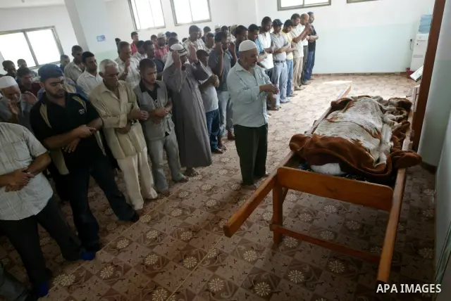 Mourners pray in front of the body of Palestinian woman Nema Abu Said during her funeral in the village of Johar a-Deek in the central Gaza Strip July 14, 2010. Israeli army shelling killed Abu Said and wounded two of he...