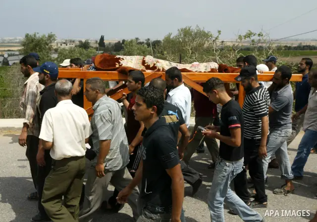 Mourners carry the body of Palestinian woman Nema Abu Said during her funeral in the village of Johar a-Deek in the central Gaza Strip July 14, 2010. Israeli army shelling killed Abu Said and wounded two of her relatives...