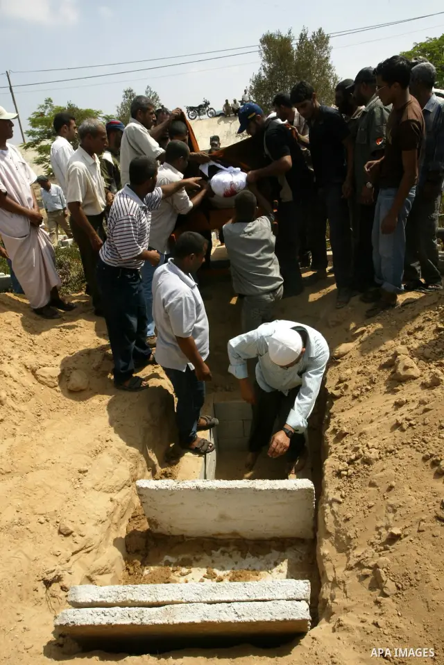 Mourners bury the body of Palestinian woman Nema Abu Said during her funeral in the village of Johar a-Deek in the central Gaza Strip July 14, 2010. Israeli army shelling killed Abu Said and wounded two of her relatives...