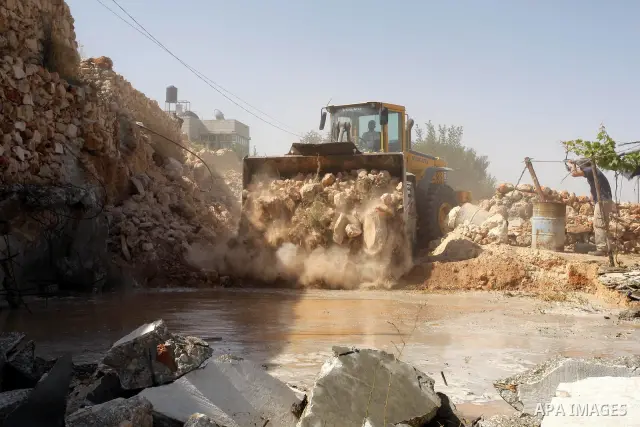 Israeli border police officers stand guard as construction vehicles destroy a man-made reservoir on a Palestinian farm near the West Bank city of Hebron on 14 July 2010. According to a spokesperson for Israel's Civil Adm...