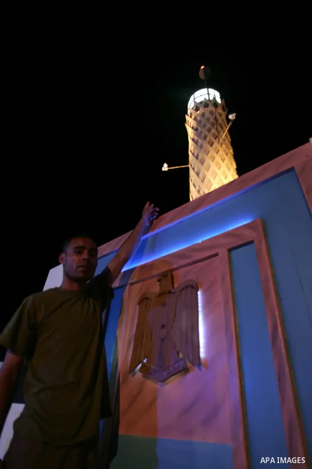 A Palestinian man stands on one side of the roof of his house in the southern Gaza Strip town of Rafah, near the border with Egypt, on July 14, 2010, where he has recreated Egypt's landmark sites with mural paintings and...