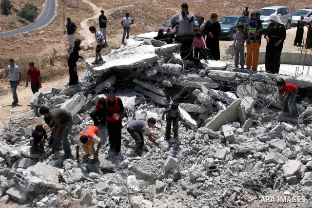Palestinians inspect a demolished house in the village of Al-Samoua near the West Bank city of Hebron on July 15 2010. The Israeli government claimed that the houses that were demolished were not licensed, but the homeow...