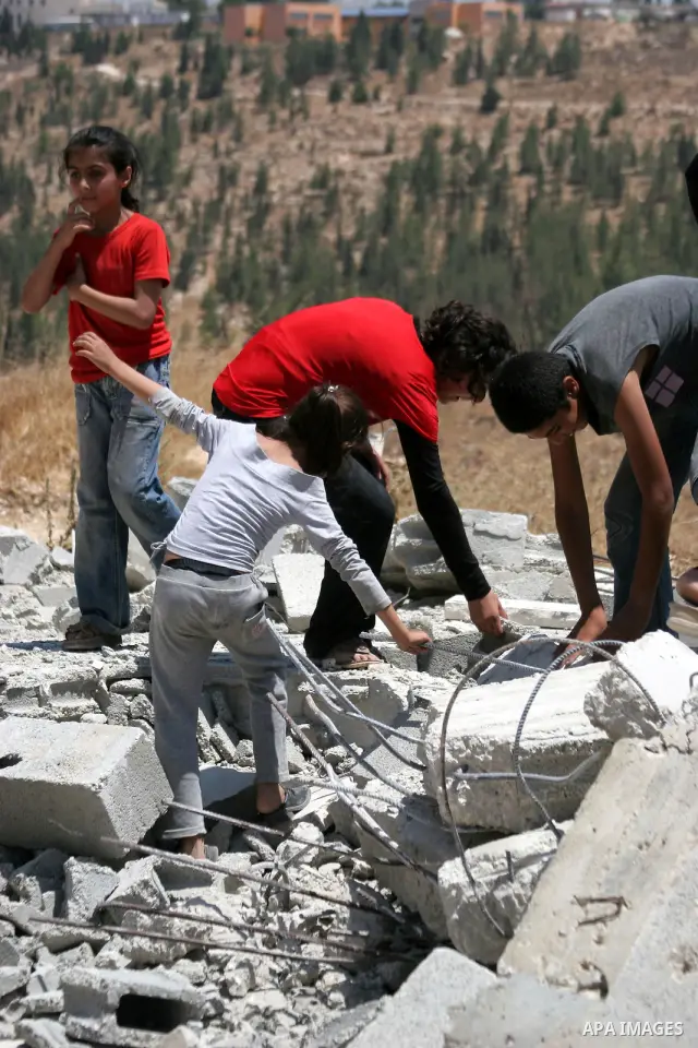 Palestinians inspect a demolished house in the village of Al-Samoua near the West Bank city of Hebron on July 15 2010. The Israeli government claimed that the houses that were demolished were not licensed, but the homeow...