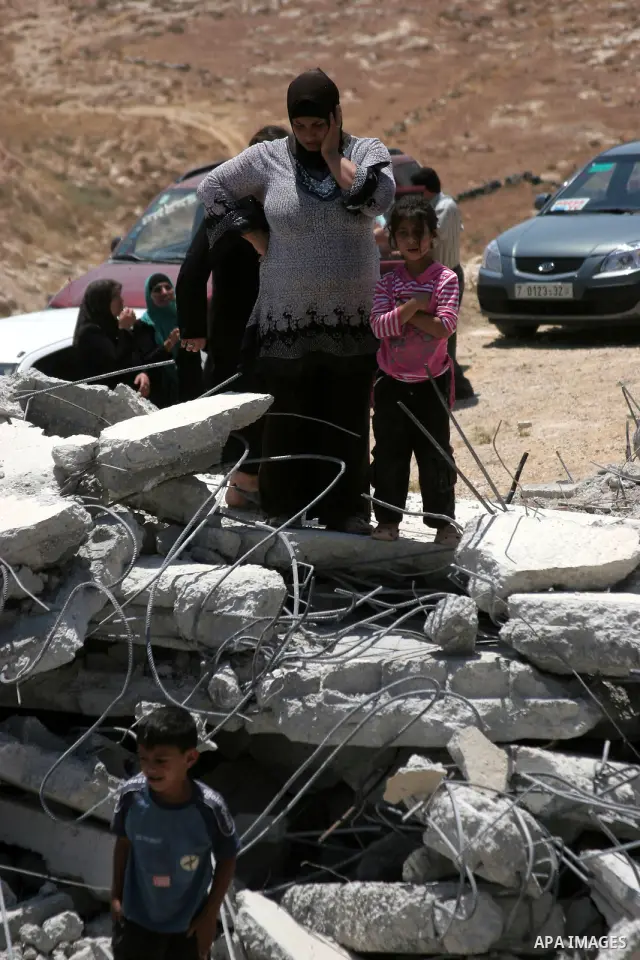 Palestinians inspect a demolished house in the village of Al-Samoua near the West Bank city of Hebron on July 15 2010. The Israeli government claimed that the houses that were demolished were not licensed, but the homeow...