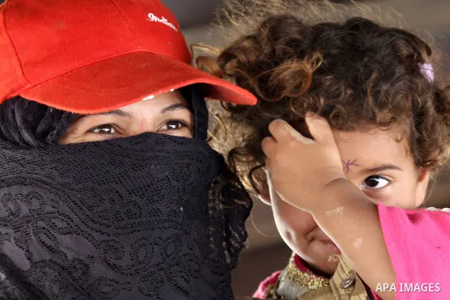 A Palestinian Bedouin woman carries her daughter in her tent on the road between Jericho and Ramallah on July 15, 2010 as Palestinian bedouins live hard life in the West Bank. Photo by Eyad Jadallah