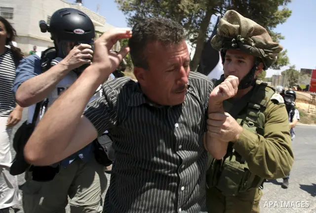 Israeli soldiers detain a Palestinian protestor during a demonstration against the expansion of the nearby Jewish settlement of Halamish in the West Bank village of Nabi Saleh near Ramallah, Friday, July 16, 2010. Photo...