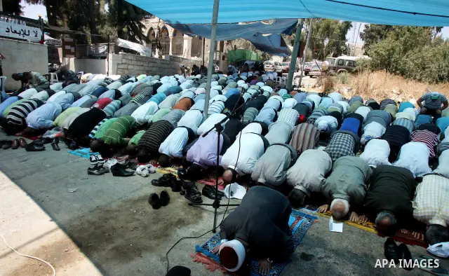 Palestinians pray in the Red Cross yard during the Friday prayer in East Jerusalem , Friday 16 July 2010, in solidarity with PLC members and former Palestinian minister Ahmad Atwon, Mohammad Totah and Khalid Abu Arfeh. A...