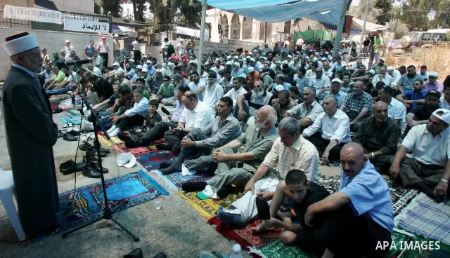 Palestinians pray in the Red Cross yard during the Friday prayer in East Jerusalem , Friday 16 July 2010, in solidarity with PLC members and former Palestinian minister Ahmad Atwon, Mohammad Totah and Khalid Abu Arfeh. A...