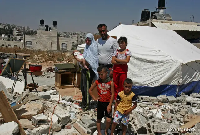 Palestinian family stand near a tent on the rubbles of their home in the Arab neighborhood of Beit Hanina in occupied east Jerusalem on July 17,2010 after Israeli army bulldozers destroyed their home. Al Rajabi family wh...