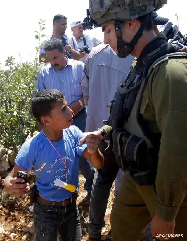A journalist is assisted by a colleague after he was injured during clashes between Israeli soldiers and demonstrators protesting against a nearby Israeli settlement near the West Bank village of Beit Omar July 17, 2010....