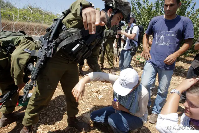 Israeli soldiers try to disperse foreign activists protesting against a nearby Israeli settlement near the West Bank village of Beit Omar July 17, 2010. Photo by Mamoun Wazwaz