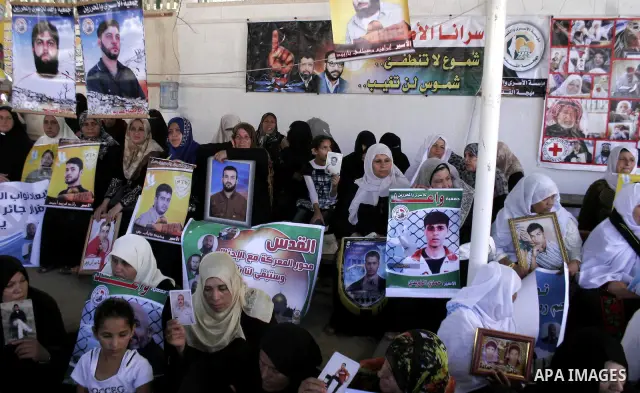 Palestinian women and children hold pictures of jailed relatives during a protest calling for the release of Palestinian prisoners from Israeli jails at the Red Cross office in Gaza City on July 19,2010. Photo by Yousef...