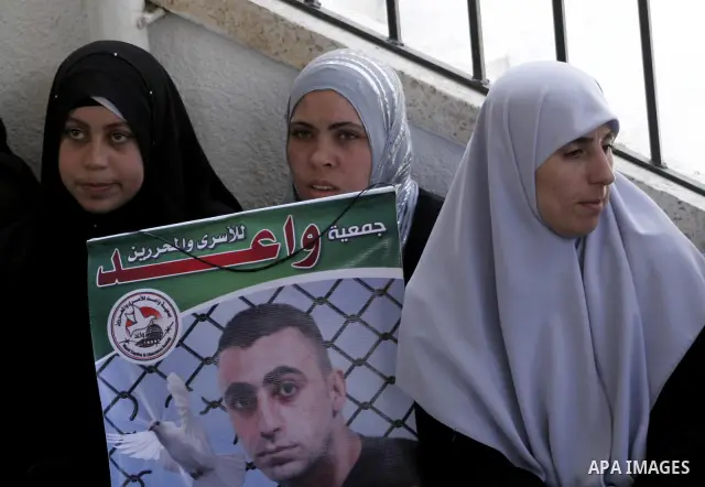 Palestinian women and children hold pictures of jailed relatives during a protest calling for the release of Palestinian prisoners from Israeli jails at the Red Cross office in Gaza City on July 19,2010. Photo by Yousef...