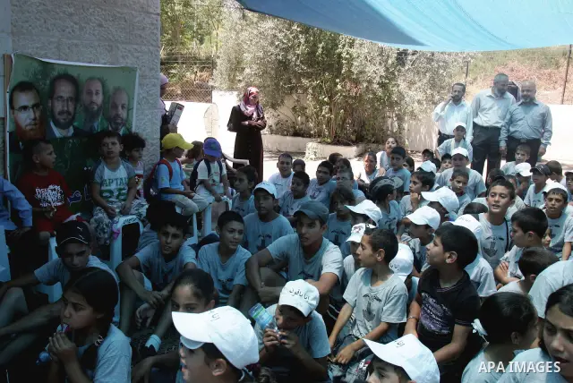 Palestinian lawmakers from Hamas movements Ahmed Atwan, Khaled Abu Arafieh and Muhammad Totah participate with Palestinian children in a protest at the International Red Cross Committee (ICRC), headquarter in East Jerusa...