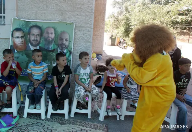 Palestinian children participate with lawmakers from Hamas movements Ahmed Atwan, Khaled Abu Arafieh and Muhammad Totah in a protest at the International Red Cross Committee (ICRC), headquarter in East Jerusalem July 19,...