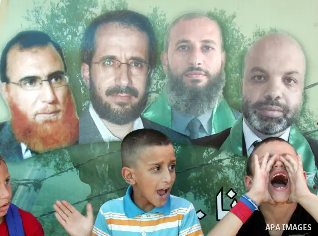 Palestinian children participate with lawmakers from Hamas movements Ahmed Atwan, Khaled Abu Arafieh and Muhammad Totah in a protest at the International Red Cross Committee (ICRC), headquarter in East Jerusalem July 19,...