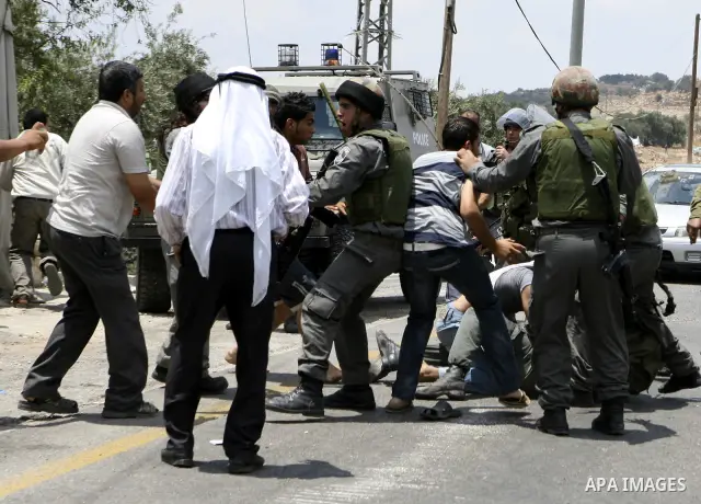 Palestinians scuffle with Israeli soldiers in the West Bank village of Lubban al-Gharbia on July 21, 2010 after Israeli forces demolished two houses and four shops that were built without the army's permit near a road le...